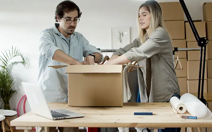 Two people packing online orders into boxes